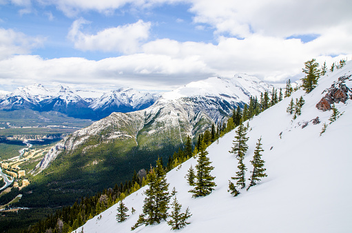 View of Rocky Mountains from gondola of Sulphur mountain during day of springtime.