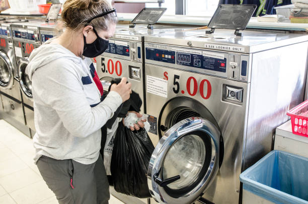 istock Woman doing laundry in laundromat 1321013750