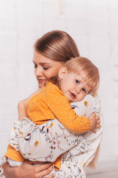 istock Young beautiful mom gently hugs her little daughter. Vertical 1321013773