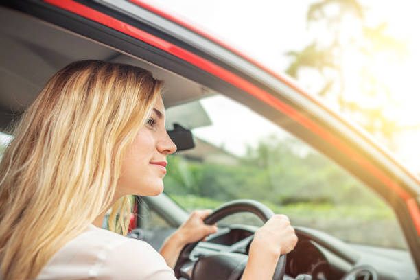 istock Happy beautiful woman is driving a red car. 1321014064