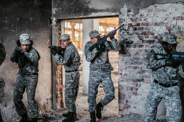 istock Military assault team stalking through corridor in abandoned building 1321015331