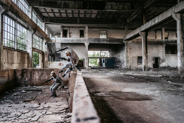 Soldiers jumping over wall to find cover in ruined building.