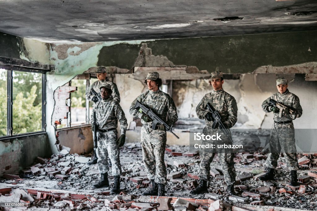 Soldier squad team portrait in urban environment Soldier squad team portrait in urban environment wearing camouflage clothes and holding weapons. Military Stock Photo