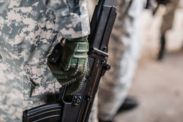 soldier holding weapon with finger on trigger - finger on the trigger imagens e fotografias de stock