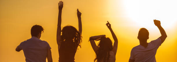 istock The four people dancing on the bright sun background 1321017355