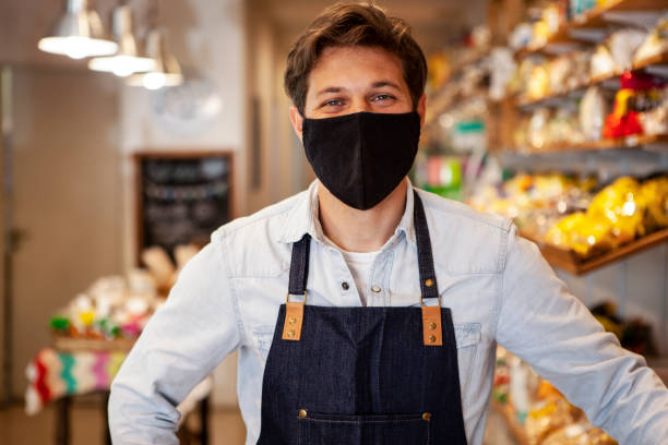 istock Portrait of young entrepreneur wearing protective face mask while standing inside healthy food store 1321017571