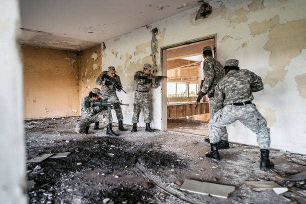 istock Military assault team stalking through corridor in abandoned building 1321017839