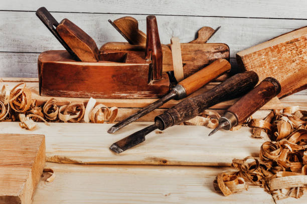 Old fashioned planes with carving chisels laying on workbench table. stock photo