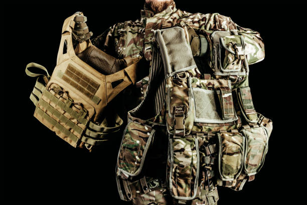 istock Soldier holding various types of camouflaged armored vests. 1321018004