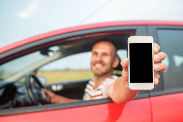 istock The driver shows a smartphone with a blank screen. 1321018133