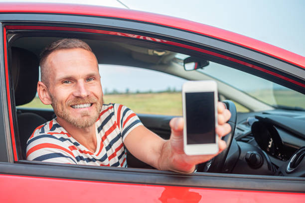 istock The driver shows a smartphone with a blank screen. 1321018137
