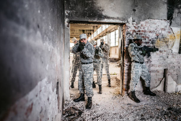 istock Military assault team stalking through corridor in abandoned building 1321018183
