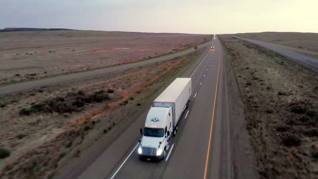 White Semi-Trailer Truck Heading Down a Four Lane Highway