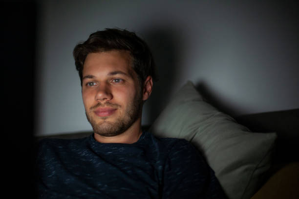 istock Portrait of young man watching contento on laptop while sitting on sofa during nightime 1321019834