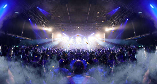 Concert crowd venue Concert crowd inside a venue, lens flare and smoke are visible. popular music concert photos stock pictures, royalty-free photos & images