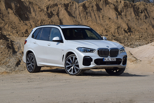 Berlin, Germany - 6th April, 2019: BMW X5 parked on the sand road. The BMW vehicles are the one of the most popular luxury cars in the world.