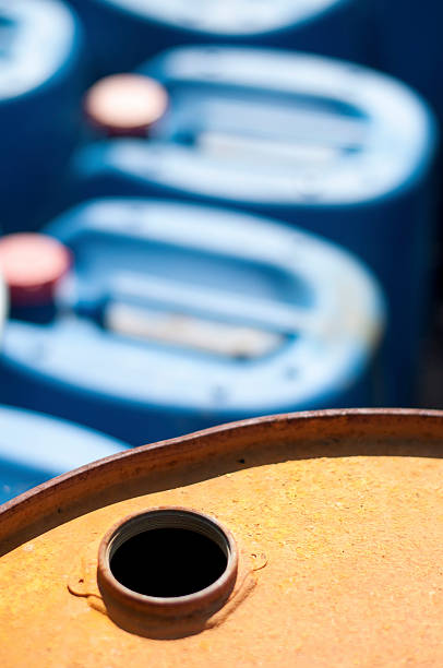Old colored barrels for oil products. Empty rusted drums and blue canisters