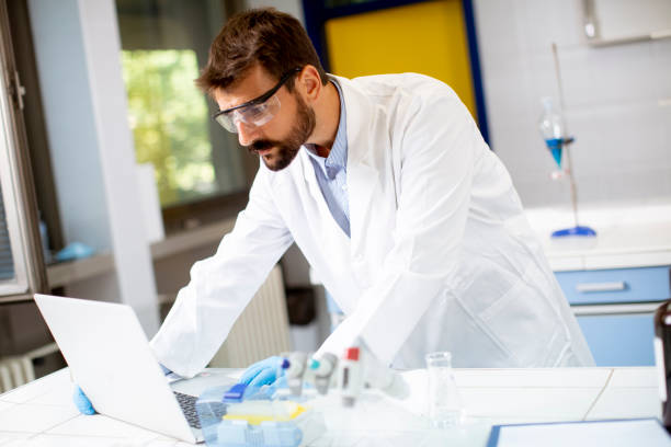 istock Researcher in white lab coat working using laptop while sitting in the lab 1321026939
