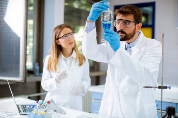 istock Researcher working with blue liquid at laboratory glass 1321027038