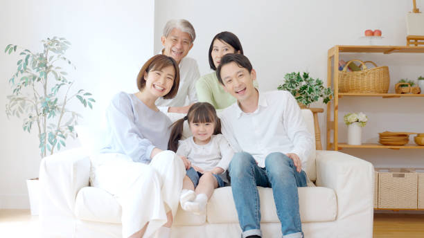 リビングルームでリラックスした3世代のアジアの家族 - 日本人　笑顔 ストックフォトと画像