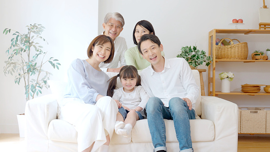 three generation asian family relaxing in the living room