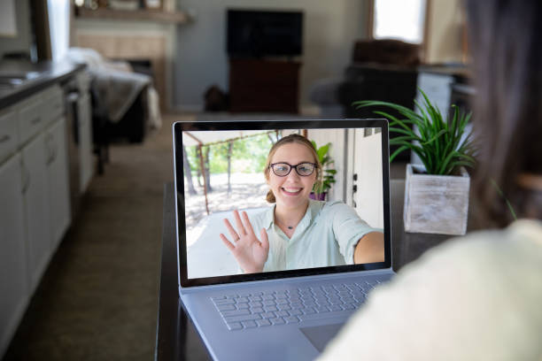 istock Woman waves from computer screen during video chat with friend or coworker 1321042663