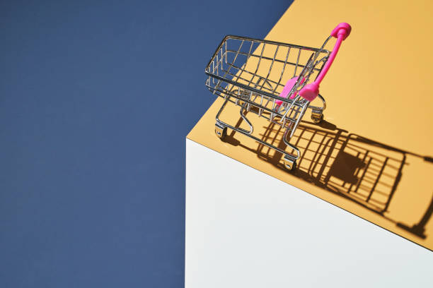 istock Shop trolley on yellow and blue bright background. Modern mall concept 1321042711