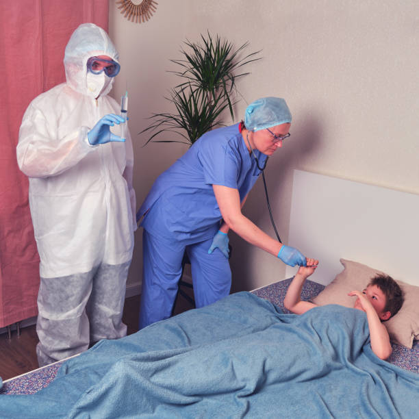 istock Doctors in protective medical uniform and sick child on home bed 1321042766