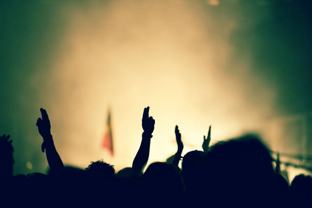istock Crowd at a music concert, audience raising hands up 1321043434