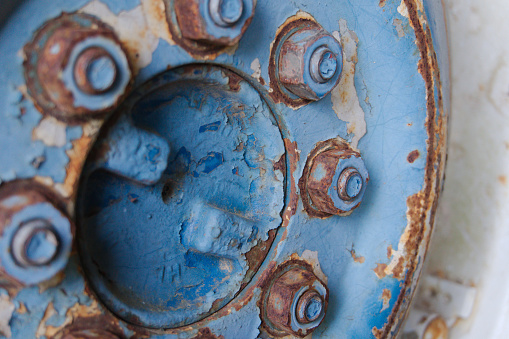 Lugnuts on an old blue tractor wheel
