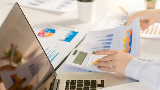 istock Businessmen analyze financial statistics with graphs and charts and calculators with a laptop and talk about the growth of Company A in an office suit. 1321046799