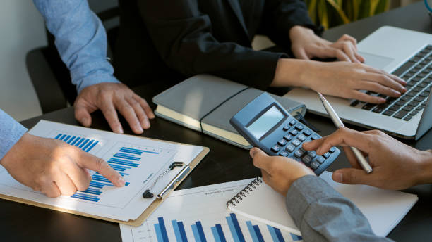 istock Businessmen analyze financial statistics with graphs and charts and calculators with a laptop and talk about the growth of Company A in an office suit. 1321046818