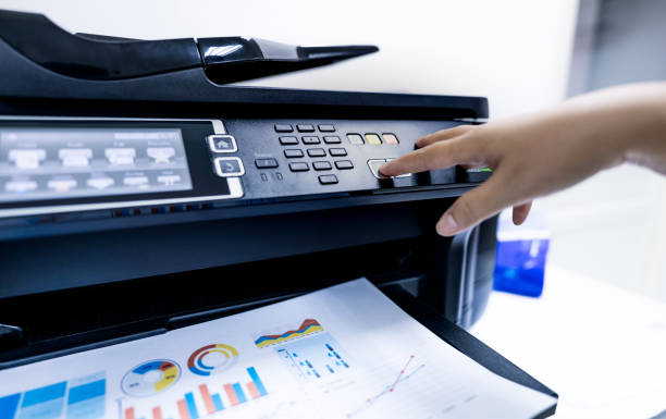 istock Office worker print paper on multifunction laser printer. Copy, print, scan, and fax machine in office. Modern print technology.  Photocopy machine. Document and paper work. Professional scanner. 1321047611
