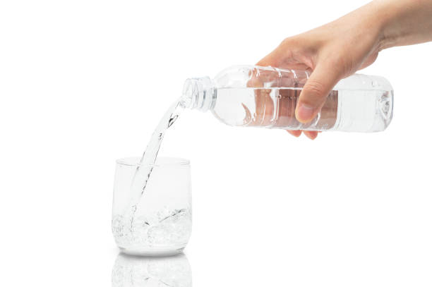 istock Man's hand pouring water into a glass. 1321050423