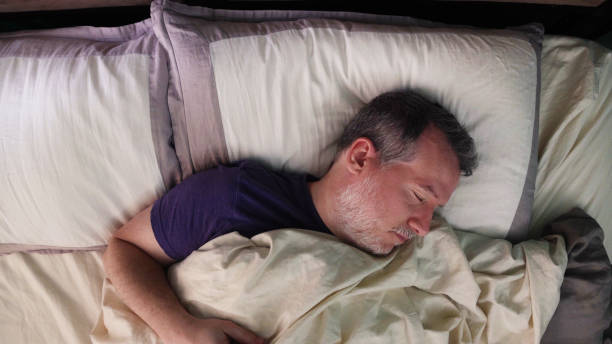 istock Mature man in bed sleeping on his back dreaming soundly 1321051357