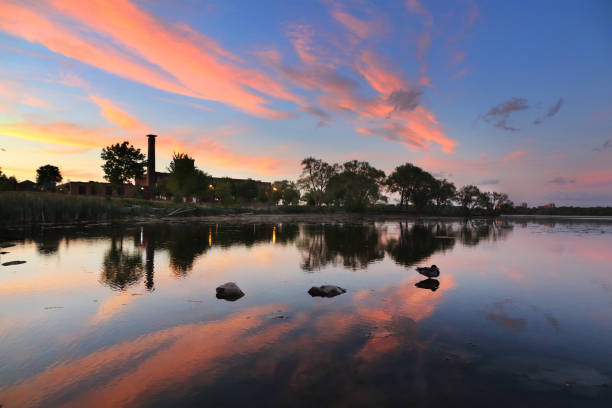Kingston Ontario Inner Harbour Sunset in the inner Harbour of Kingston, Ontario on the Cataraqui River. Historic mill in the background, two rocks and a duck in the foreground. kingston harbour stock pictures, royalty-free photos & images