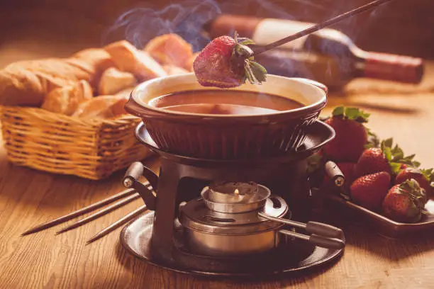 Chocolate fondue with oven on wooden table
