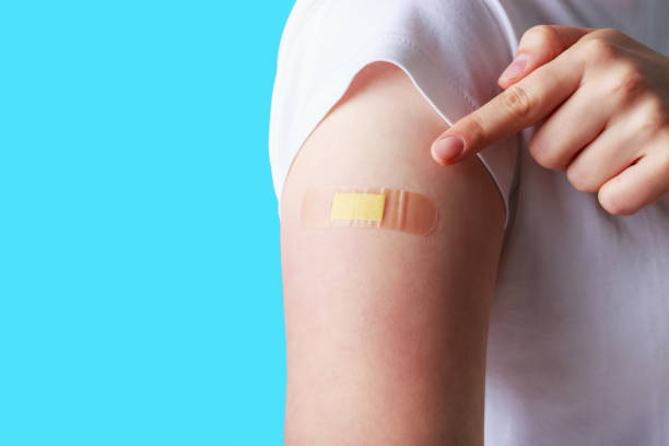 istock Female hand with adhesive plaster on blue background, vaccination concept. 1321061697