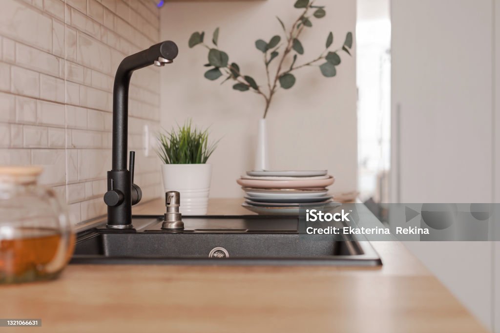 Zwarte gootsteen die van kunstmatige steen in een houten huisbinnenland wordt gemaakt. - Royalty-free Aanrecht Stockfoto