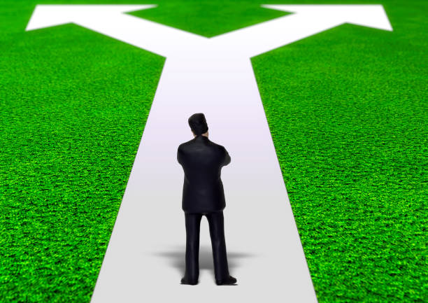 A businessman who branches off with the concept of business and stands on the white arrow A businessman who branches off with the concept of business and stands on the white arrow challenges and Opportunities Challenges, Land Acquisition stock pictures, royalty-free photos & images