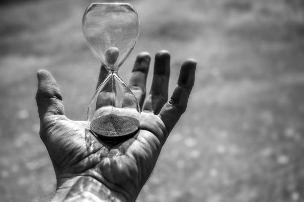 istock Hand with expiring hourglass with copy space 1321067095