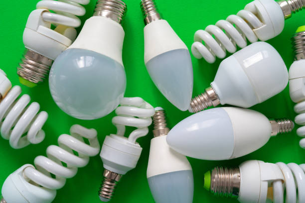 istock Light bulb on green paper background close up 1321071440