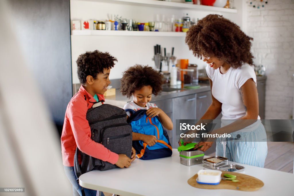 Mother Making School Lunch Mother making school lunch to her children. Back to School Stock Photo