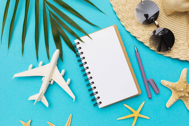 istock Blank notebook, pen, toy plane and sunglasses on blue background 1321073643