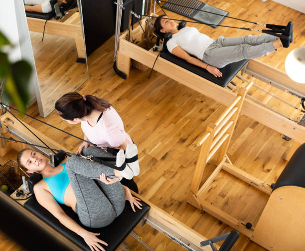 istock Female pilates trainer helping pilates woman during training 1321076726