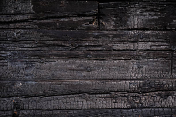 istock Burnt wooden Board texture. Burned scratched hardwood surface. Charred board 1321076828