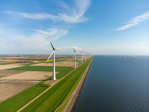 Wind turbines on a levee and offshore in Flevoland, The Netherlands, during springtime seen from above. Flevoland is a modern polder in the former Zuiderzee designed initially to create more land for farming.