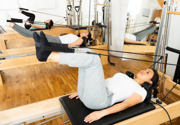 istock Young Latina practicing pilates on reformer at gym 1321077113