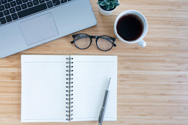 istock flat lay composition with notebook, pen, coffee, plant, laptop on wood background. top view 1321079834