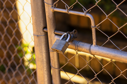 Locked gate with padlock.